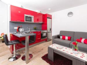 sala de estar con cocina roja y sofá en Casa Silva, en Calheta