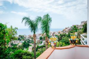 
a view from a balcony of a beach with palm trees at Eden House Positano in Positano

