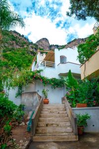 un escalier menant à un bâtiment blanc orné de fleurs dans l'établissement Eden House Positano, à Positano