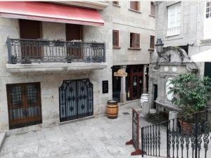 a building with a gate and a balcony and a door at Fonte Zeta in Baiona