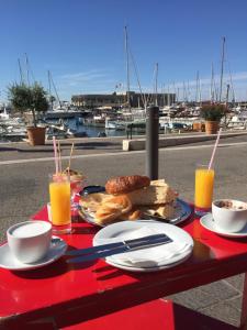 een rode tafel met ontbijtproducten en drankjes erop bij Studio 29 Cassis in Cassis