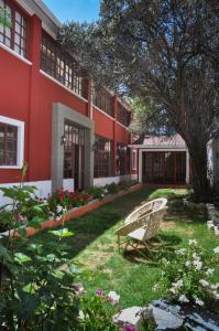 un banco en el patio de un edificio rojo en Anami Hotel Boutique en La Paz