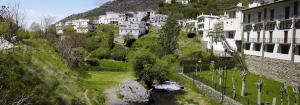 a town on a hill with a river and buildings at Casa Rosa in Trevélez