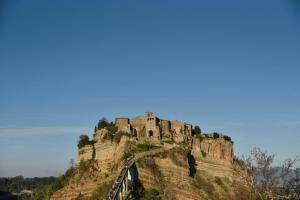 un château au sommet d'une montagne avec un pont dans l'établissement La dimora di Civita, à Bagnoregio