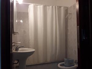 ein Badezimmer mit Duschvorhang und Waschbecken in der Unterkunft Hotel La Maison in La Lucila del Mar