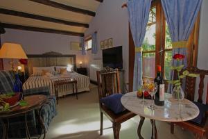 een woonkamer met een bed en een tafel met wijnglazen bij Casa Glebinias in Chacras de Coria
