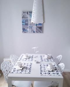 ウストロニエ・モルスキエにあるApartament Ku Morzu Ustronie Morskieの白いダイニングテーブル(白い椅子付)