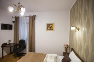 ein Schlafzimmer mit einem Bett, einem Schreibtisch und einem Stuhl in der Unterkunft History Apartments Cetății in Sibiu