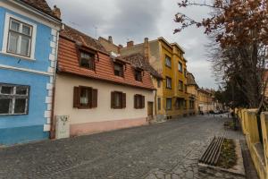 eine Kopfsteinpflasterstraße in einer Stadt mit bunten Häusern in der Unterkunft History Apartments Cetății in Sibiu
