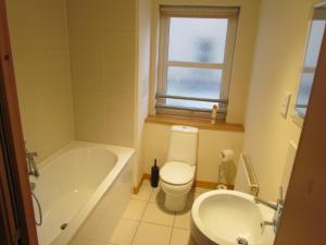 een badkamer met een bad, een toilet en een wastafel bij Farraline Court in Inverness +6 foto's