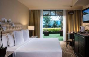 a bedroom with a large white bed and a window at Hotel Marquis Reforma in Mexico City