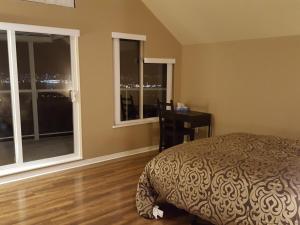 a bedroom with a bed and a desk and windows at Emperial Suites in North Vancouver