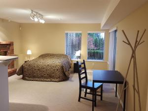 a bedroom with a bed and a desk and a table at Emperial Suites in North Vancouver