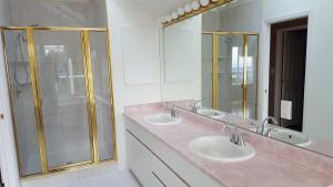 a bathroom with three sinks and a shower at Emperial Suites in North Vancouver