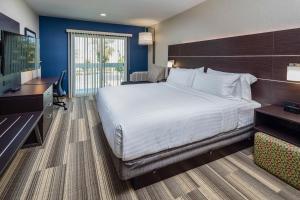 ein Hotelzimmer mit einem großen Bett und einem Schreibtisch in der Unterkunft Holiday Inn Express - Sunnyvale - Silicon Valley, an IHG Hotel in Sunnyvale