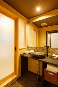 La salle de bains est pourvue d'un lavabo et d'un miroir. dans l'établissement Rinn Gojomibugawa East, à Kyoto