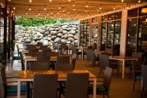 a restaurant with tables and chairs and a stone wall at Bridges Bay Resort in Arnolds Park