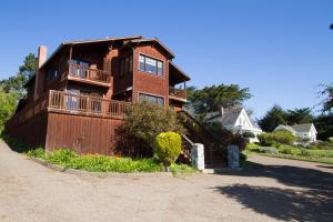 a large brick house with a balcony on a street at Mendocino View East in Mendocino