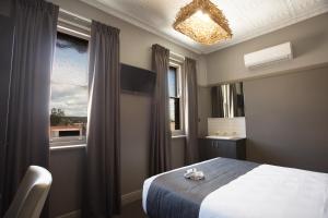 a bedroom with a bed and a window at Nags Head Hotel in Newcastle