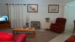 a living room with a couch chair and a tv at Casa Bella in Tamworth