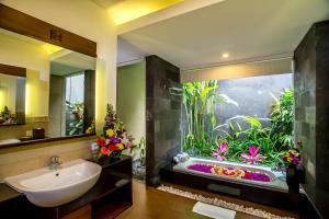 - une salle de bains avec un grand aquarium à côté d'un lavabo dans l'établissement Kori Ubud Resort, Restaurant & Spa, à Ubud
