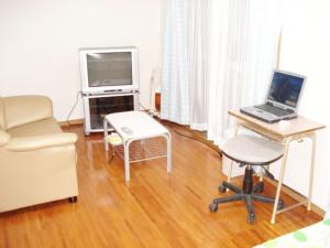 a living room with a laptop computer on a desk at BIGJOY INN Hirokouji in Miyako-jima