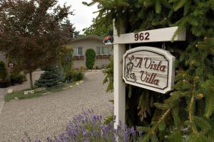 znak po stronie domu z kwiatami w obiekcie A Vista Villa Couples Retreat w mieście Kelowna