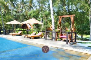 a pool with chairs and a swing next to a swing set at Vyaana Resort Gili Air in Gili Islands