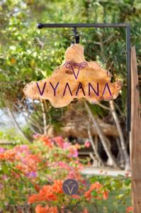 Ein Schild, auf dem steht, dass Hyänen vor Blumen hängen. in der Unterkunft Vyaana Resort Gili Air in Gili Air