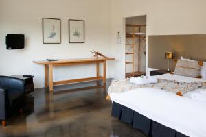 twee bedden in een kamer met een bureau aan de muur bij Saladin Lodge in Narbethong