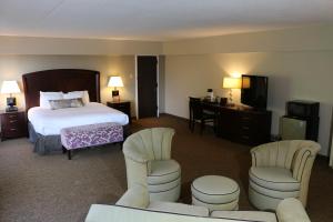 a hotel room with a bed and two chairs at The Avalon Hotel and Conference Center in Erie