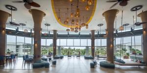 a large lobby with tables and chairs and chandeliers at SOL by Meliá Phu Quoc in Phu Quoc