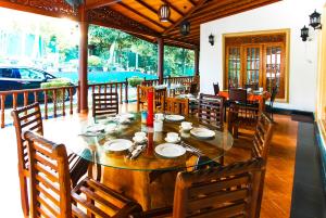 een eetkamer met een houten tafel en stoelen bij Green View Holiday Resort in Kandy