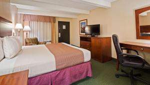 a hotel room with a bed and a desk with a computer at Best Western Montis Inn in Saint Robert +2 photos