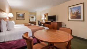une chambre d'hôtel avec un lit et une table dans l'établissement Best Western Montis Inn, à St. Robert