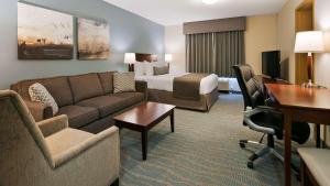 een hotelkamer met een bank en een bed bij Best Western Rocky Mountain House in Rocky Mountain House