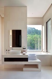寧波的住宿－寧波柏悅酒店，一间带水槽和浴缸的浴室以及窗户。