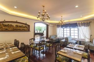 a restaurant with tables and chairs and a piano at Villa Ibarra in Tagaytay
