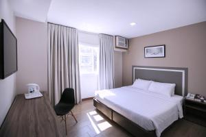 a hotel room with a bed and a chair at S Hotel & Residences in Cebu City