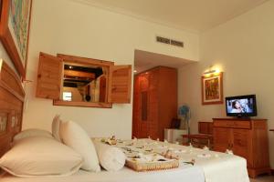 a bedroom with a bed with pillows and a tv at The Oasis Beach Resort in Hambantota