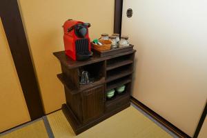 a small cabinet with a red appliance on it next to a door at Rinn Yasaka Kodaiji in Kyoto