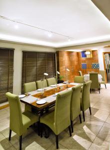 uma sala de jantar com uma mesa de madeira e cadeiras verdes em The Zehneria By Sarovar Portico India em Nairobi