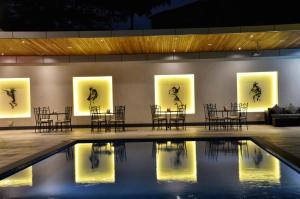 una habitación con sillas y mesas y una piscina en The Zehneria Hotel, en Nairobi