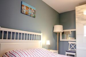 sypialnia z łóżkiem i niebieską ścianą w obiekcie Apartament Kapitański Bursztynowe Komnaty w Darłówku