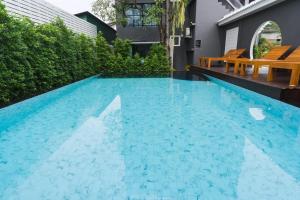 uma piscina com água azul numa casa em The Besavana Phuket - SHA Extra Plus em Phuket