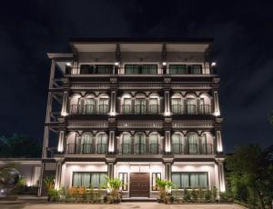 a tall building with lights on it at night at The Besavana Phuket - SHA Extra Plus in Phuket Town