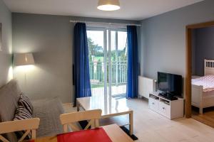 salon z kanapą, łóżkiem i telewizorem w obiekcie Apartament Kapitański Bursztynowe Komnaty w Darłówku