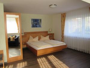 a bedroom with a large bed and a mirror at Gästehaus Wörner in Durbach +37 photos