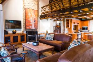 a living room with leather furniture and a fireplace at Hluhluwe Lodge by ANEW in Hluhluwe