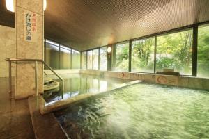 a large pool of water in a building with windows at Kasuga no Mori in Saku